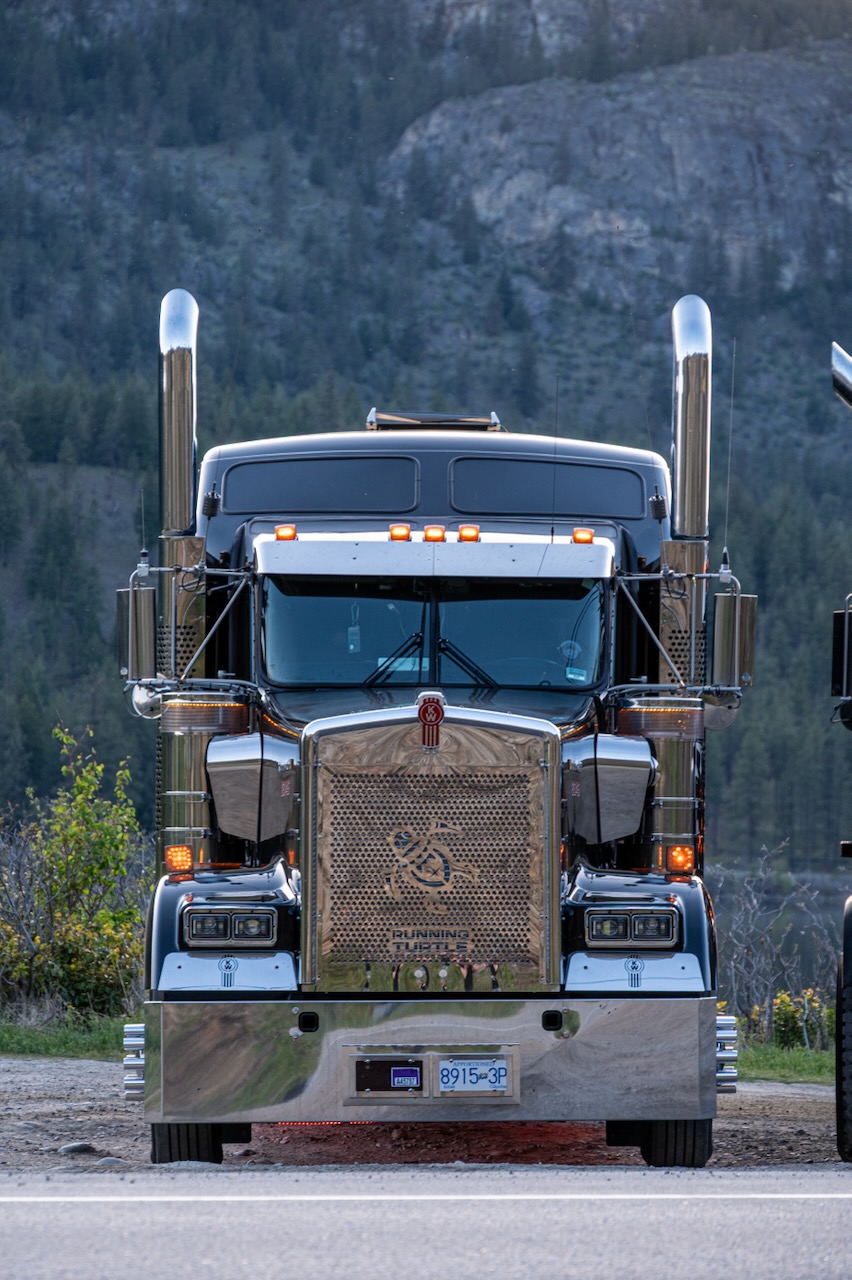 Front of a Running Turtle Kenworth tractor against a mountain landscape